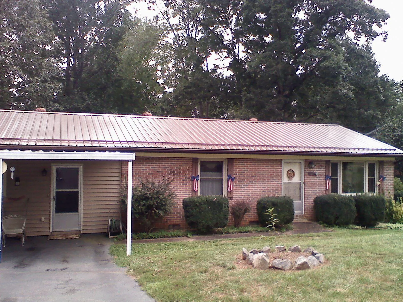 Bronze metal roof and carport on a brick ranch home — Roof Repair work by our crew in Farragut
